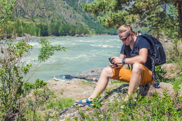 Un touriste avec un téléphone et un sac à dos sur les montagnes à la surface