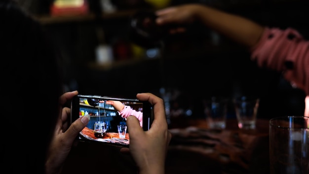 Touriste utilisant un smartphone pour enregistrer une vidéo d'une machine à thé dans la communauté des cafés du comptoir à chiang rai en thaïlande