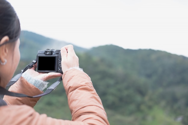 Touriste utiliser la caméra pour prendre une photo de la vue sur la montagne.