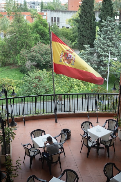 Un touriste en vacances assis sur une terrasse avec le drapeau d'Espagne