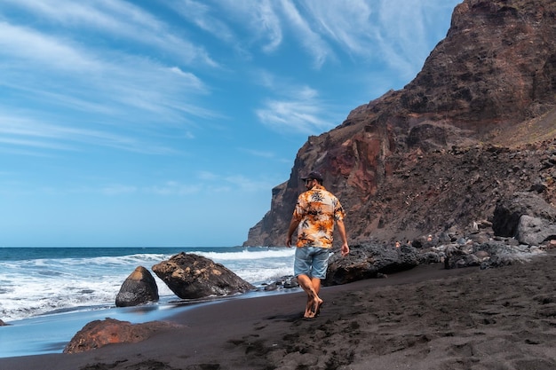 Touriste en vacances sur la plage de sable volcanique noir d'Ingles à Valle Gran Rey sur les îles Canaries de La Gomera