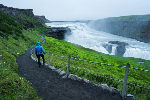 Touriste en voyage près de la cascade de Gullfoss en Islande