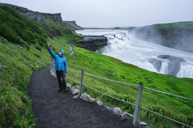 Touriste en voyage près de la cascade de Gullfoss en Islande