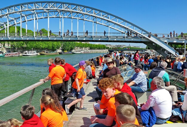 les touristes et les adolescents en t-shirts orange vif montent sur un bateau de plaisance sur le sein paris