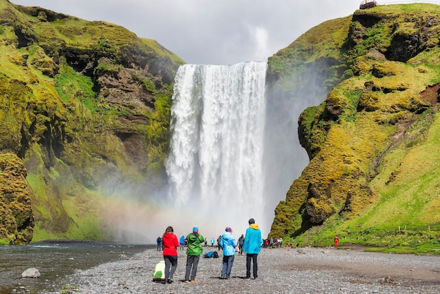 Les touristes apprécient la cascade de Skogafoss, la plus grande cascade de Skogar, en Islande.