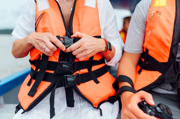 Touristes, bateau, mettre, gilet de sauvetage