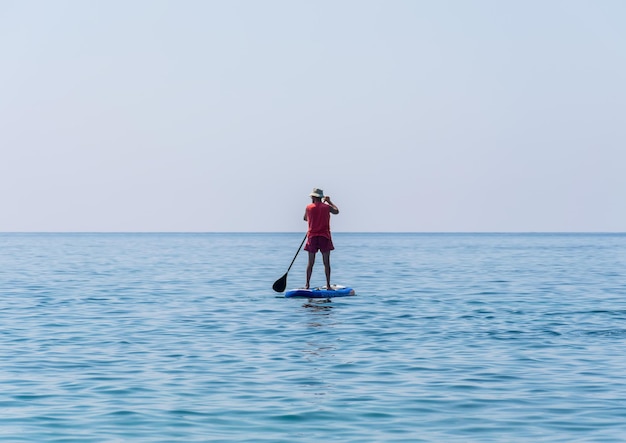 Les touristes du MONTENEGRO BUDVA s'adonnent à l'aviron sur la planche de SUP à la surface de la mer calme