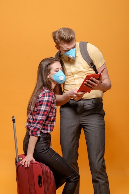 Photo les touristes fatigués les voyageurs homme et femme dans des masques médicaux pandémie de coronavirus fermé les pays frontaliers grande valise