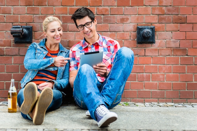 Touristes hipster planifiant des vacances à Berlin avec ordinateur pad