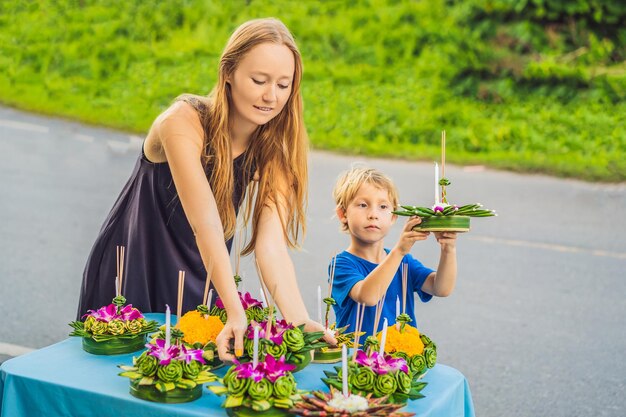 Les touristes de maman et fils célèbrent Loy Krathong Courent sur l'eau Festival Loy Krathong Les gens achètent des fleurs et des bougies pour s'allumer et flotter sur l'eau pour célébrer le festival Loy Krathong en Thaïlande