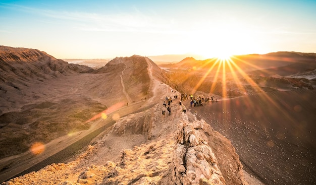 Des touristes méconnaissables regardant le coucher du soleil sur la montagne de formations rocheuses à Valle De La Luna dans le célèbre désert d'Atacama au Chili Randonnée d'aventure dans le sud de l'Amérique latine merveille de la nature