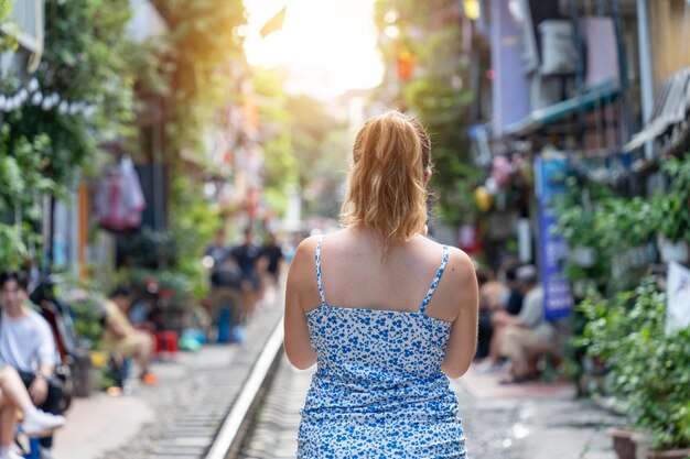 Touristes prenant des photos d'un train qui dévale La rue du train de Hanoï est une attraction populaireVue du train traversant une rue étroite du vieux quartier de Hanoï