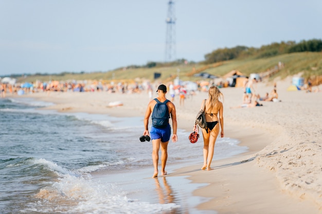 Les touristes se détendent dans la mer et sur la plage de sable