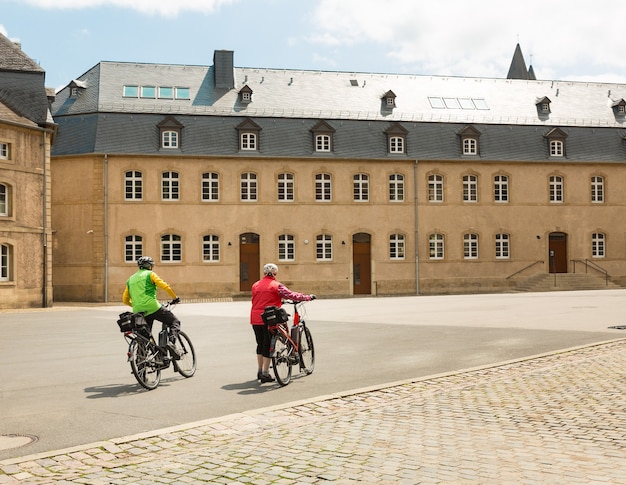 Les touristes à vélo, vieille rue de la ville européenne