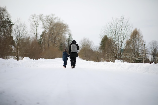 Les touristes voyagent à travers le pays enneigé. Sur le chemin, marchez et faites de l'auto-stop.