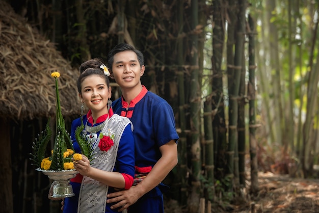 Tournage avant le mariage à l'intérieur du jardin en costumes traditionnels thaïlandais