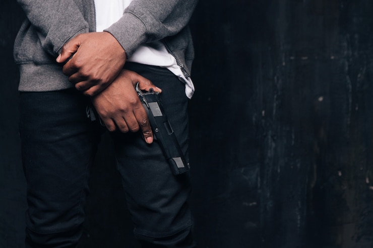 Photo tournage en studio d'un criminel noir armé méconnaissable