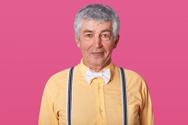 Photo tourné horizontal d'homme mûr aux cheveux gris positif avec la peau ridée