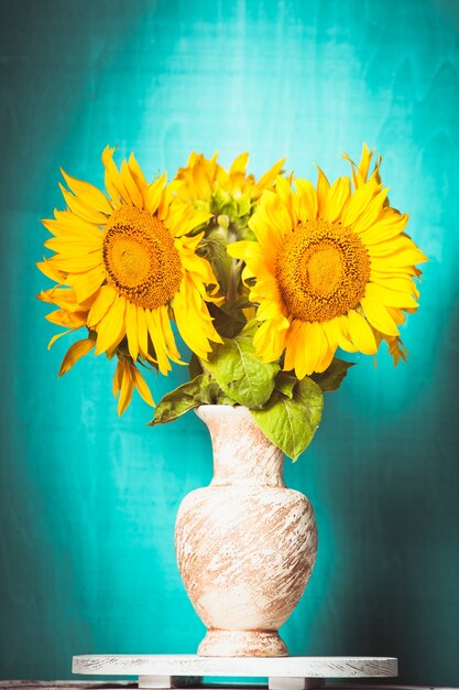 Tournesol dans le vase sur fond de bois bleu