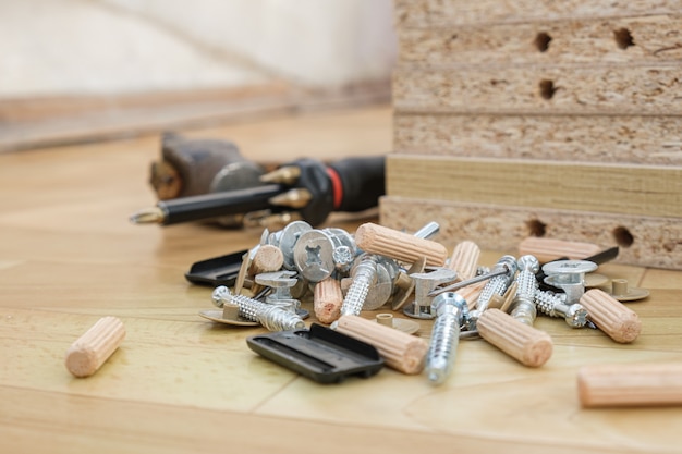 Photo tournevis avec embouts amovibles et pièces pour assembler des meubles sur des parties de meubles d'armoire