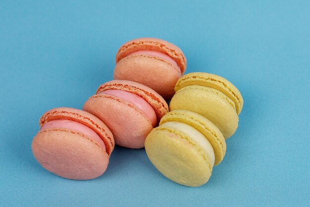 Photo tours de macaronis dans des tons pastel jaunes et roses sur fond bleu