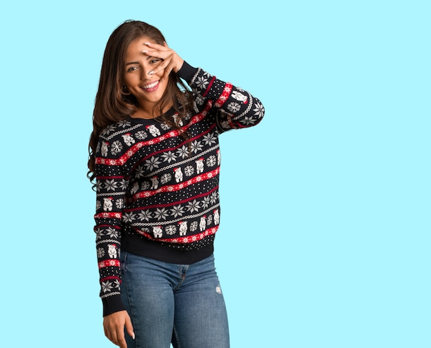 Tout le corps jeune femme portant un maillot de Noël gêné et riant en même temps