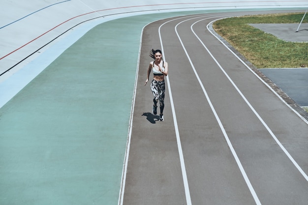 tout est possible. vue de dessus pleine longueur de jeune femme en vêtements de sport en cours d'exécution