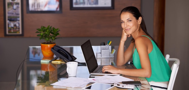 Tout en une journée de travail Une belle jeune femme à la recherche de contenu alors qu'elle travaille depuis son bureau à domicile