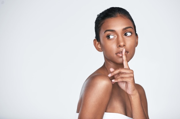 Tout le monde veut savoir quel est mon secret Photo d'une belle jeune femme posant sur un fond blanc