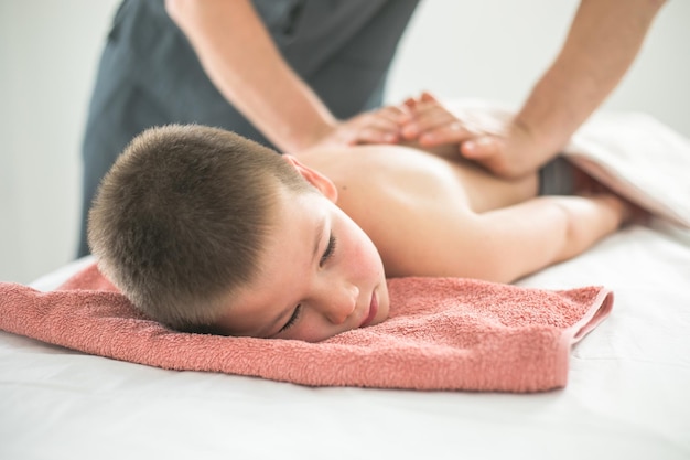 Tout-petit garçon se détend d'un massage thérapeutique Physiothérapeute travaillant avec un patient en clinique pour traiter le dos d'un enfant