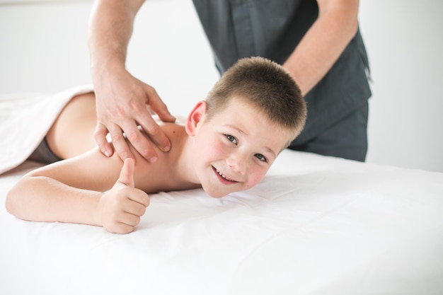 Tout-petit garçon se détend d'un massage thérapeutique Physiothérapeute travaillant avec un patient en clinique pour traiter le dos d'un enfant