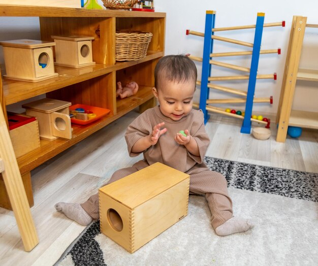 Tout-petit jouant avec la boîte de formes Montessori Imbucare