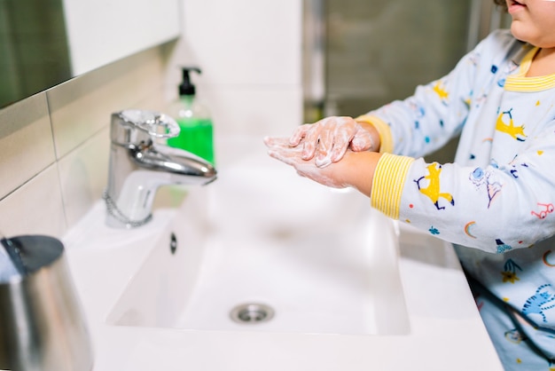 Tout-petit se lave les mains avec du savon pour prévenir et se protéger contre le coronavirus Covid 19