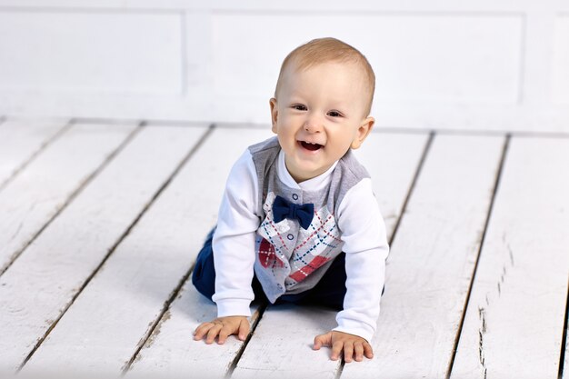 Tout-petit souriant rampe sur flor dans le salon