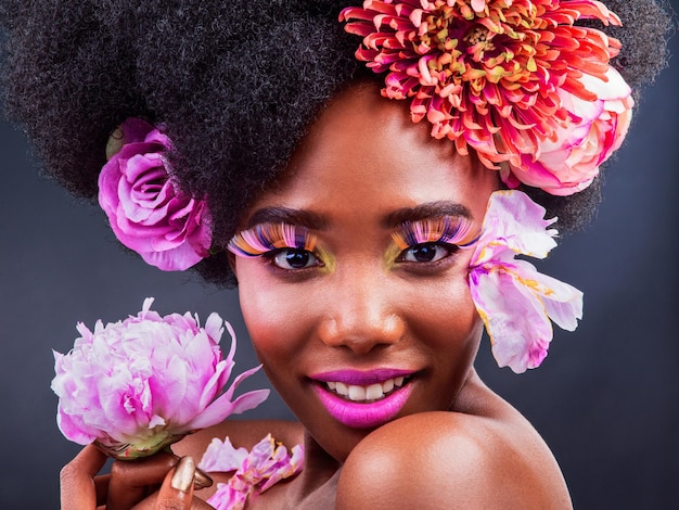 Tout ce que vous avez à faire est d'ajouter un peu de rose Studio photo d'une belle jeune femme posant avec des fleurs dans les cheveux