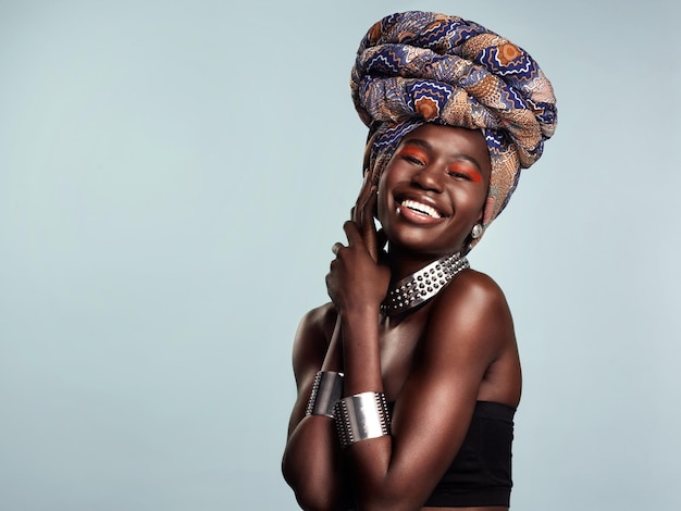 Photo tout ce qui vous fait briller, faites-le studio photo d'une belle jeune femme portant un foulard traditionnel africain sur un fond gris