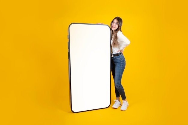 Toute la longueur du corps caucasian girl leaning big énorme smartphone maquette de téléphone mobile écran blanc