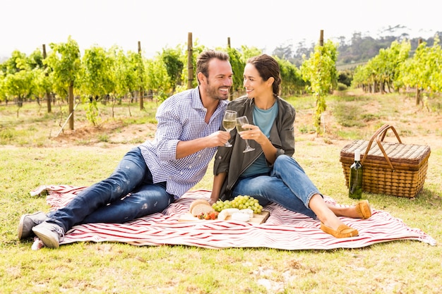 Toute la longueur du couple heureux grillage des verres à vin