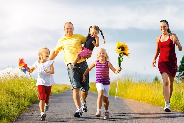 Photo toute la longueur de la famille marchant sur la route contre le ciel