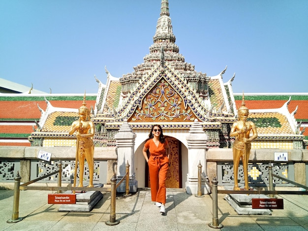 Toute la longueur d'une femme debout contre le temple