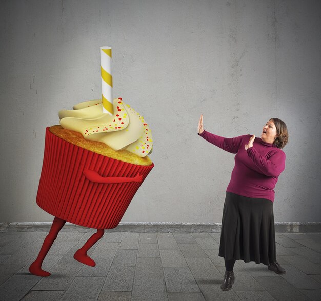 Photo toute la longueur d'une femme sur un gâteau contre le mur