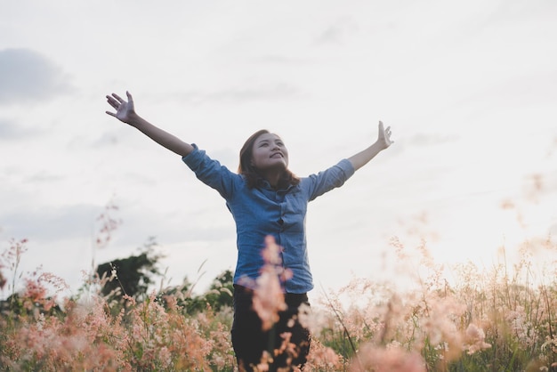 Photo toute la longueur d'une femme heureuse debout sur le champ contre le ciel