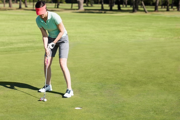 Toute la longueur de la femme jouant au golf