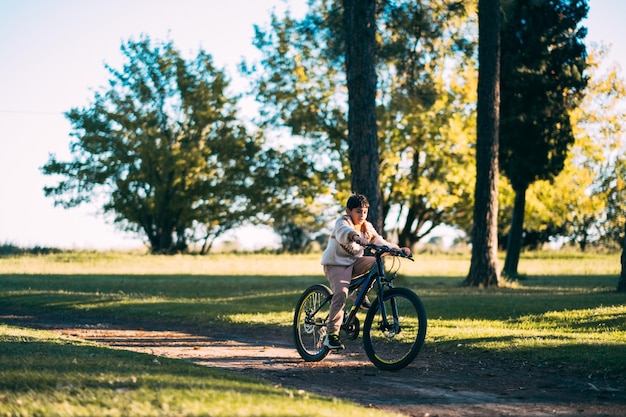Toute la longueur d'une fille à vélo sur le terrain