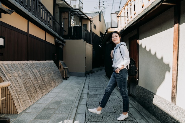 toute la longueur de la jeune fille asiatique routard de voyage debout sur la route dans l'allée Ishibe kyoto au japon. touriste voyageant seule en marchant dans la rue. belle femme tourisme ville attraction