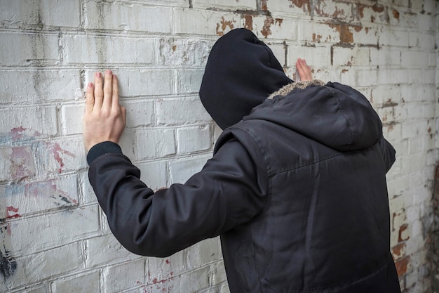Toxicomane seul dans un bâtiment abandonné contre un mur de briques blanches Vue latérale Stop dope