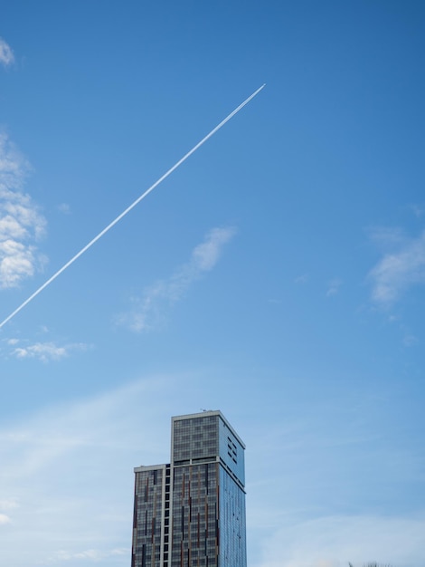 Photo une trace du vol d'un avion sur la toile de fond d'un grand bâtiment