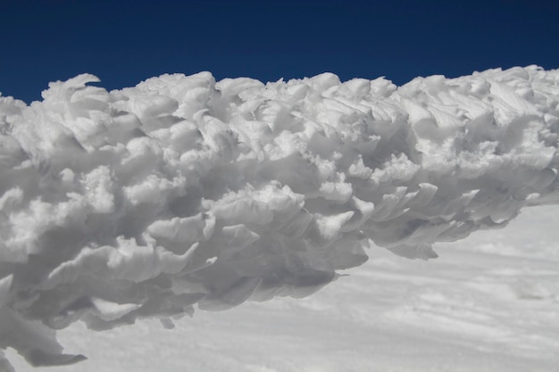 Traces d'activité éolienne Neige gelée devant le ciel bleu