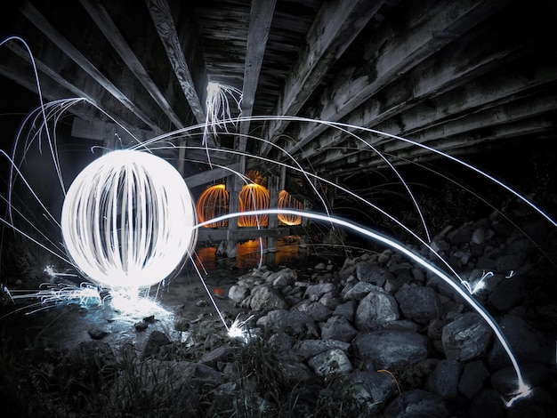 Photo des traces de lumière dans l'eau la nuit.