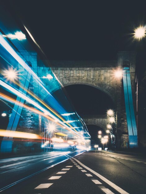Photo des traces de lumière sur le pont en ville contre un ciel clair la nuit